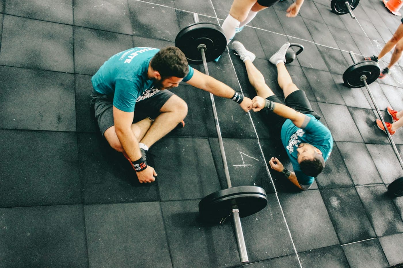 A trainer and his client fist-bump after a heavy deadlift set